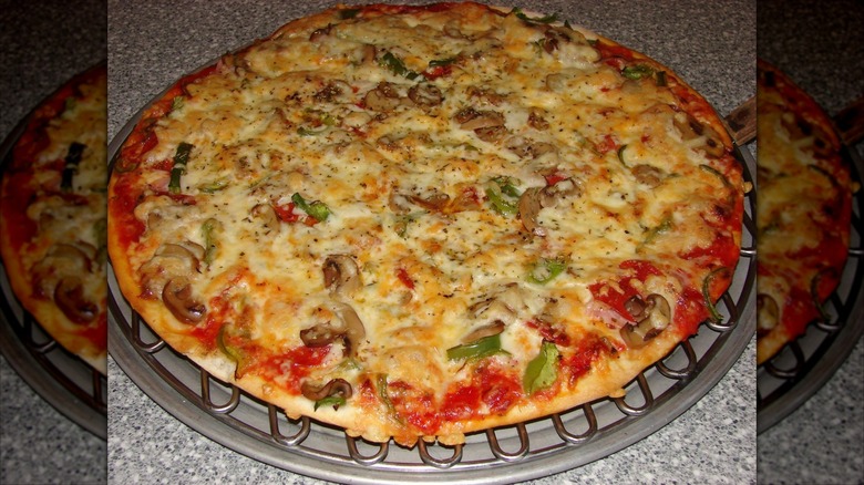 Cheese pizza with mushrooms and greens on silver tray