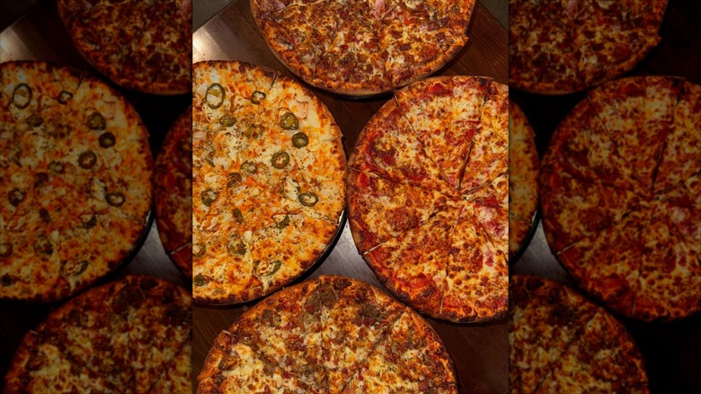 Four pizzas on wooden table