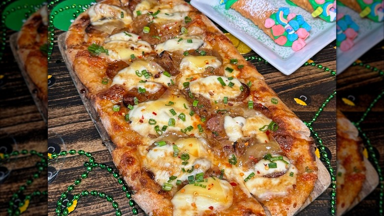 Pizza Rock pizza surrounded by Mardi Gras beads on wooden table