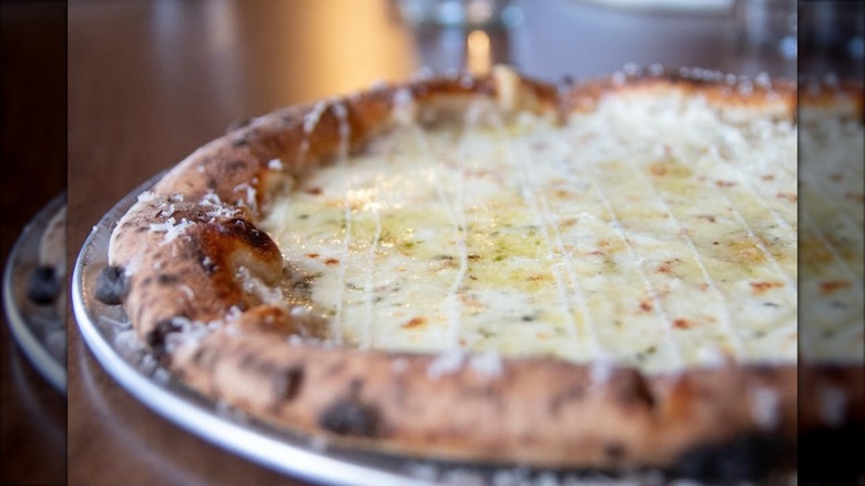Four cheese pizza on silver tray