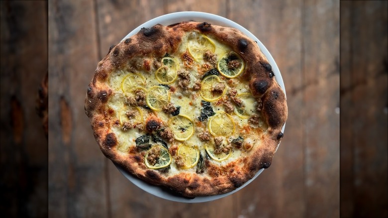 Lemon topped pizza on white plate