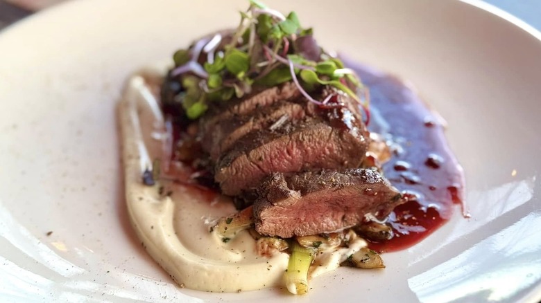 Steak with sauces on plate at Washington Prime