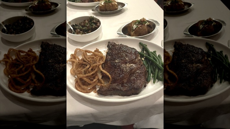 Steak, fried onions, green beans on plate at Bern's Steak House
