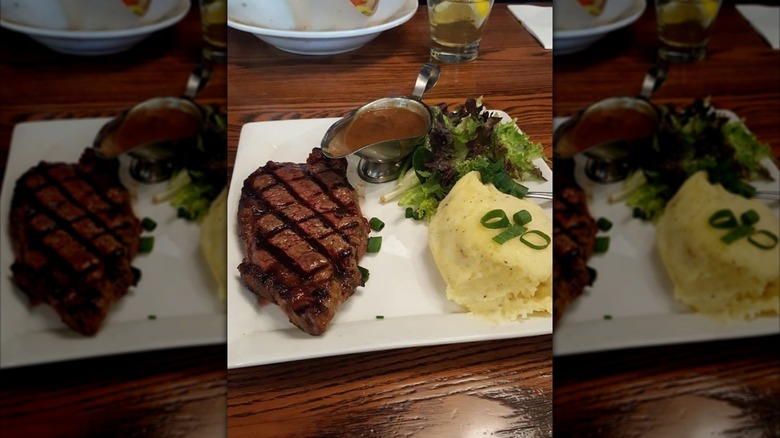 Steak, potatoes, and salad on plate at Lock, Stock, and Barrel Steakhouse