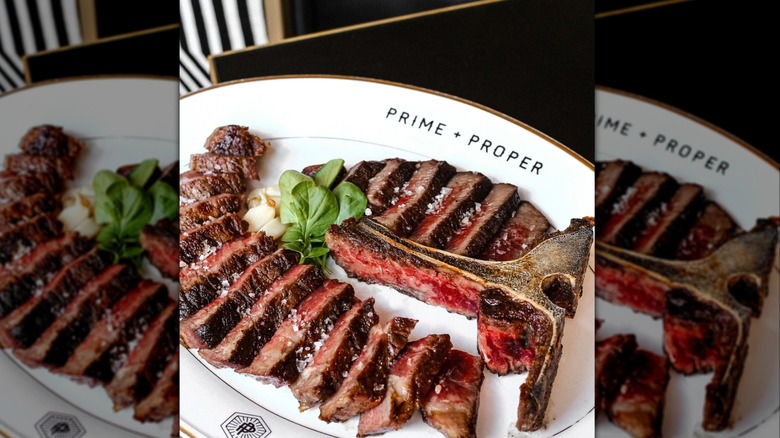 sliced steak on a plate with bone at Prime and Proper