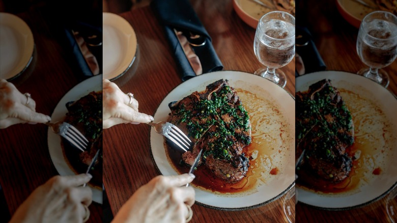 overhead shot of a person cutting into a prepared steak at Timbers