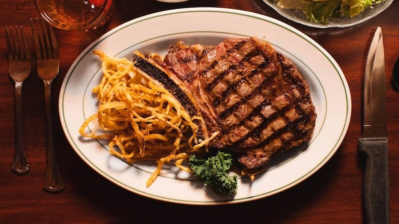 a steak plated with crispy onions at The Pine Club