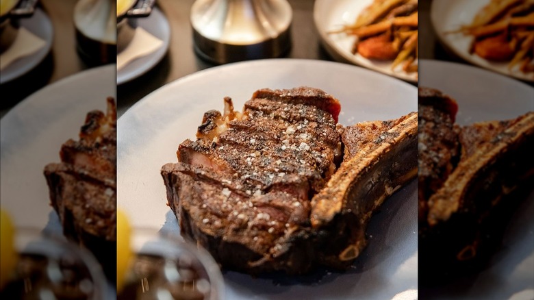 sliced steak sprinkled with salt on plate at Knife restaurant