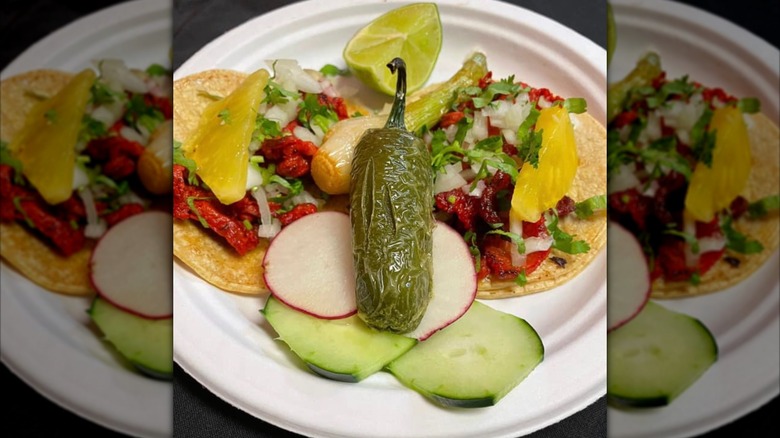 Al pastor tacos with pineapple, radishes, onion, cilantro and a pepper
