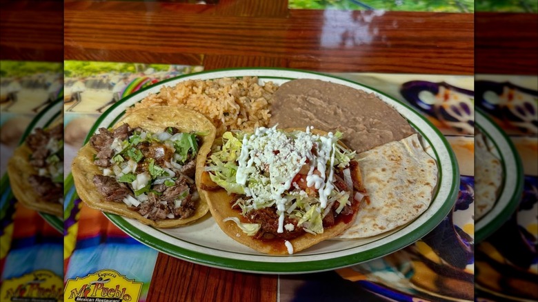 A plate of beef tacos, rice, and beans