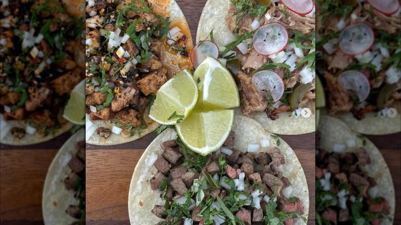Three tacos on a table with lime wedges