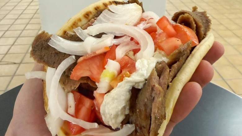 Hand holding a Gryro from John's Grecian Deli