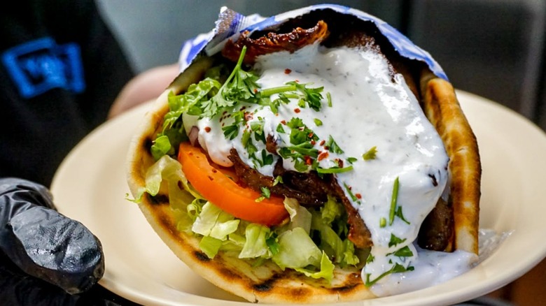 Gloved hand holding Gyro from Yanni's Greek Grill