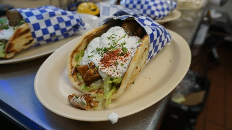 Gyro wrapped in blue and white checkered wrapper from Yianni's Gyros on a white platter