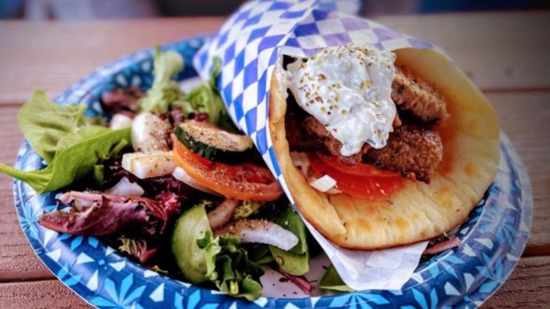 Gyro from Santorini Cafe with a Greek salad, on a blue paper plate
