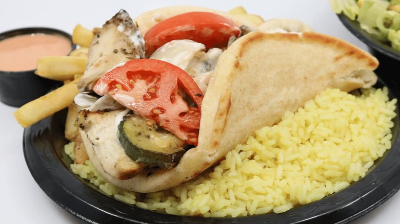 Chicken Gyro from Greek Souvlaki on a bed of rice on a black plate