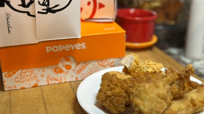 KFC, Chick-fil-A & Popeyes boxes with cut open tenders in foreground