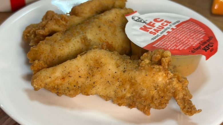 KFC tenders on a plate with sauce