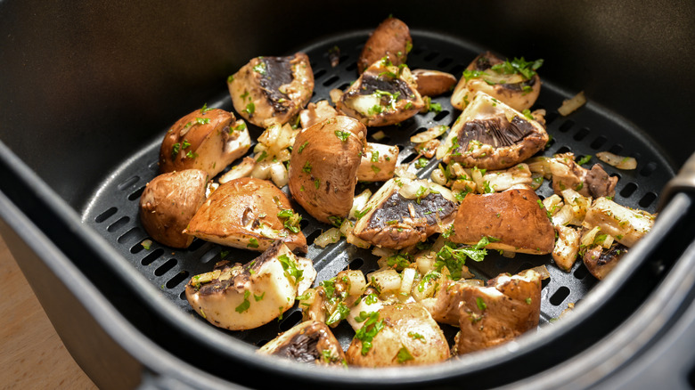 Quartered mushrooms cooking in an air fryer