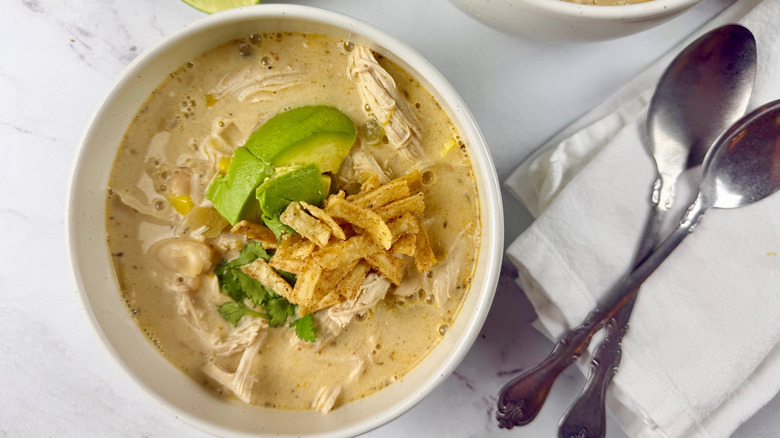 bowl of chicken chili with sliced avocado