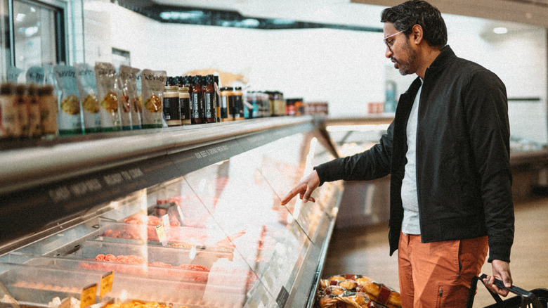 Person looking at case in meat and seafood department at grocery store