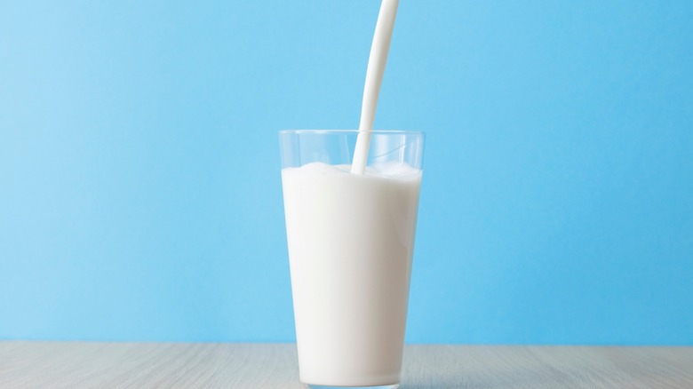 A glass of milk being poured.