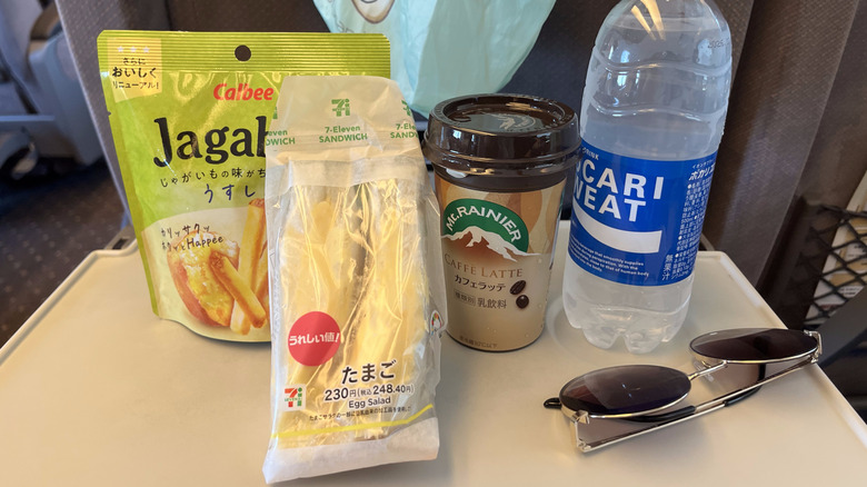 7-Eleven egg sandwich, chips, and drinks on a table.