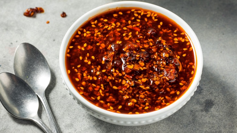White bowl of chili oil with spoons