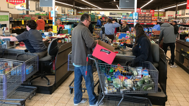 Seated cashiers checking out customers at an Aldi store