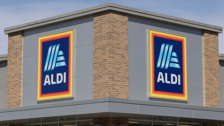 Corner brown brick facade of supermarket with the Aldi logo on the two sides