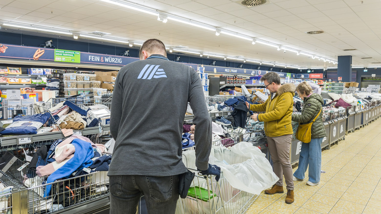 An Aldi employee pushing a shopping cart through the store