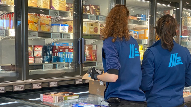 Employees checking inventory at Aldi