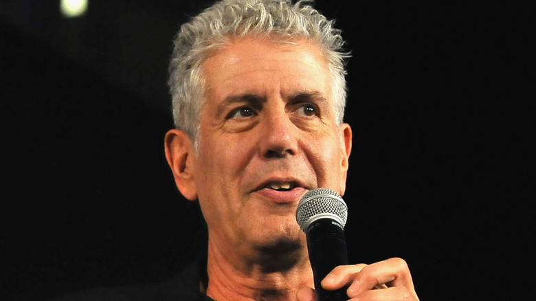 Anthony Bourdain speaking into microphone