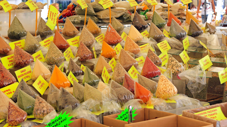 An array of plastic bagged spices in a market