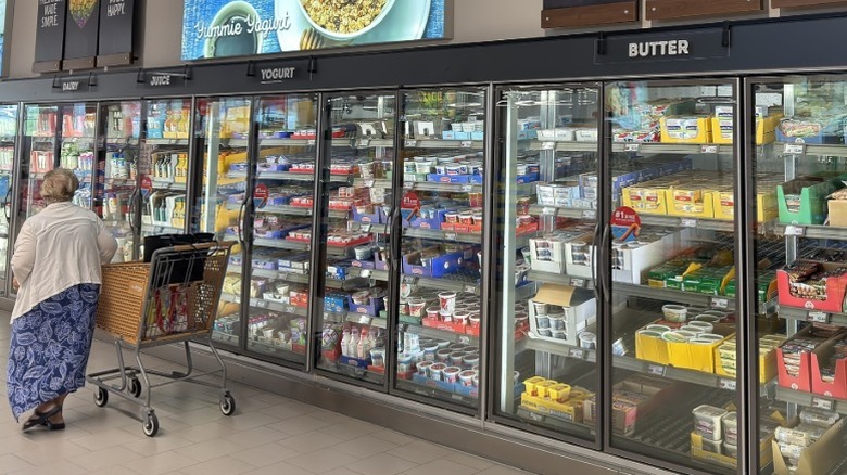 Woman shops in dairy section at Aldi.