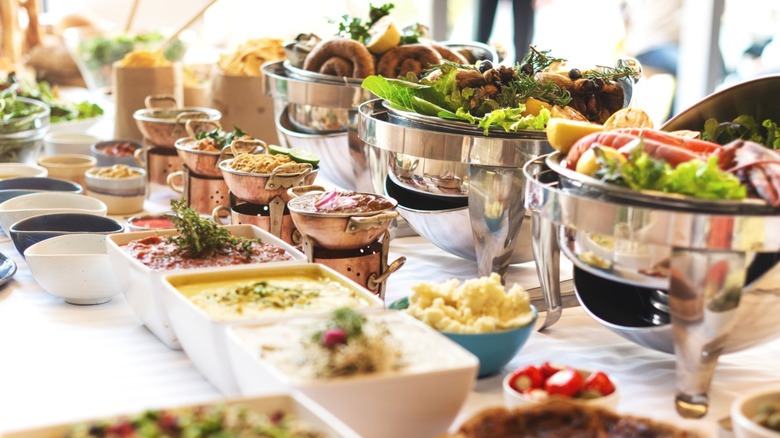 A setup at a buffet, prominently featuring salad.