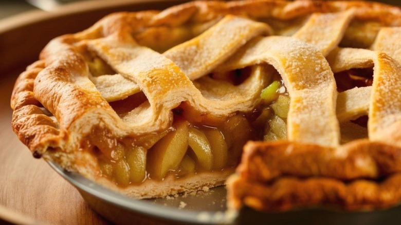 Close-up of apple pie with slice missing in a metal pan