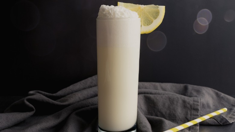 A Ramos Gin Fizz cocktail with a slice of lemon