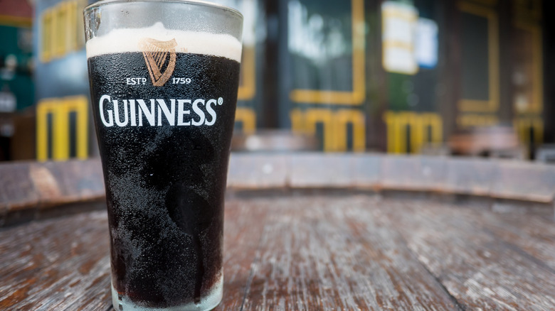 A glass of Guinness on a wooden barrel outside