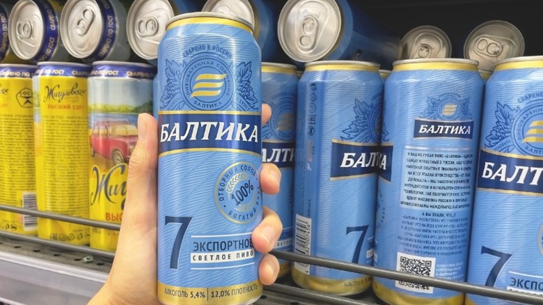 A can of Russian beer being held by a shopper at a Russian supermarket