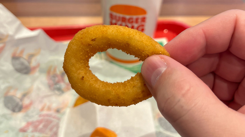 Someone holding up a Burger King onion ring