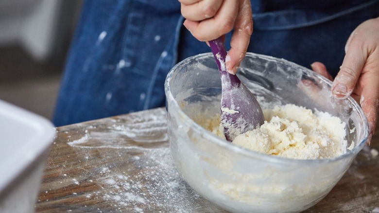 A baker mixing together cake batter.