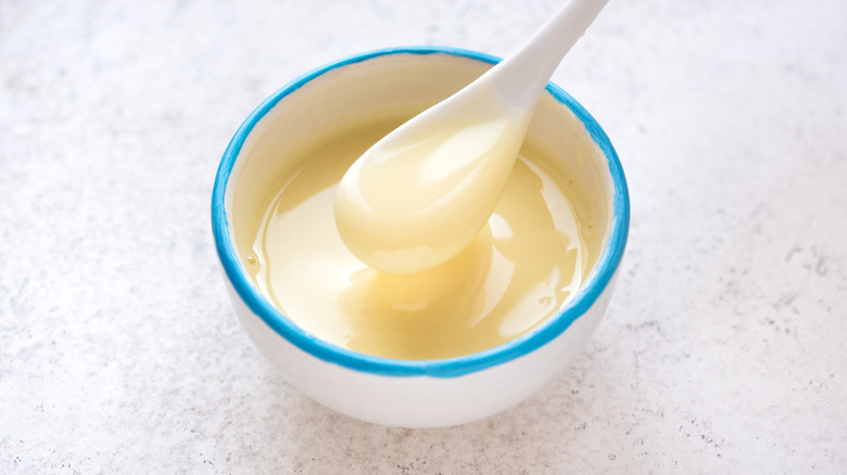 sweetened condensed milk in a white bowl with a blue rim