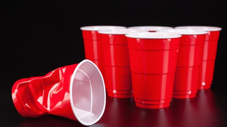 A beer pong setup with one crushed up, symbolizing the dangers of alcohol.
