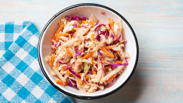 A white bowl full of vinegar-based coleslaw