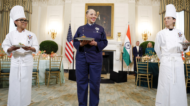 Three White House chefs holding up plates