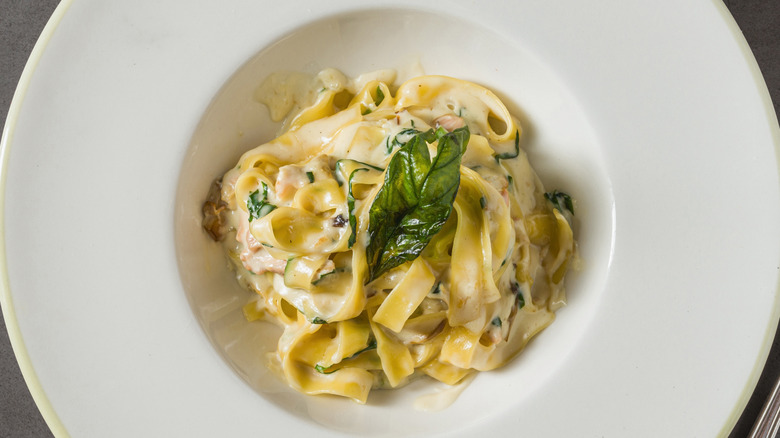 Top view of creamy fettuccine Alfredo pasta in white restaurant plate