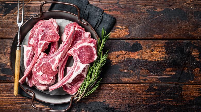 Uncooked lamb chops and fresh rosemary