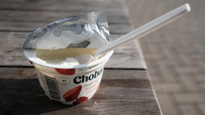 An open pot of Chobani strawberry flavored Greek yogurt with a spoon