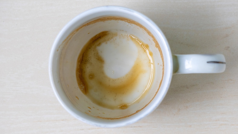 Top view of a white mug with coffee stains